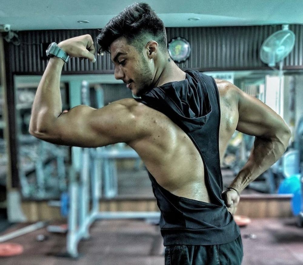 Sanchit showing arm and back development in the gym